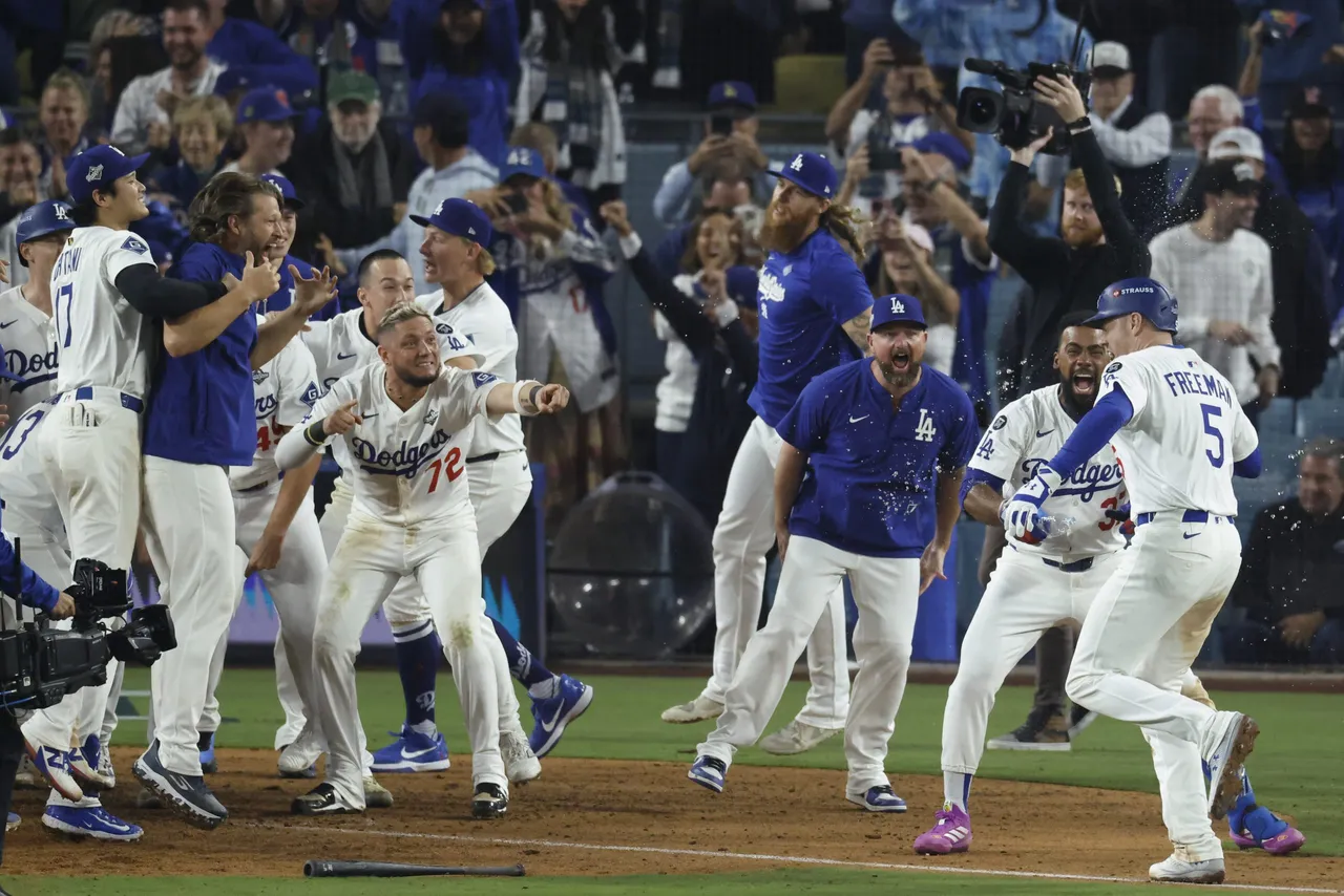 Los Angeles Dodgers Freddie Freeman (R) gets mobbed by his teammates