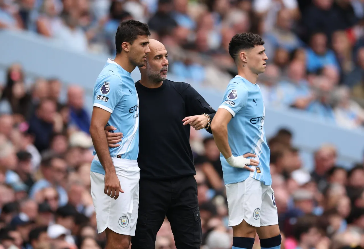 Manchester City manager Pep Guardiola speaks to Rodri of Manchester City