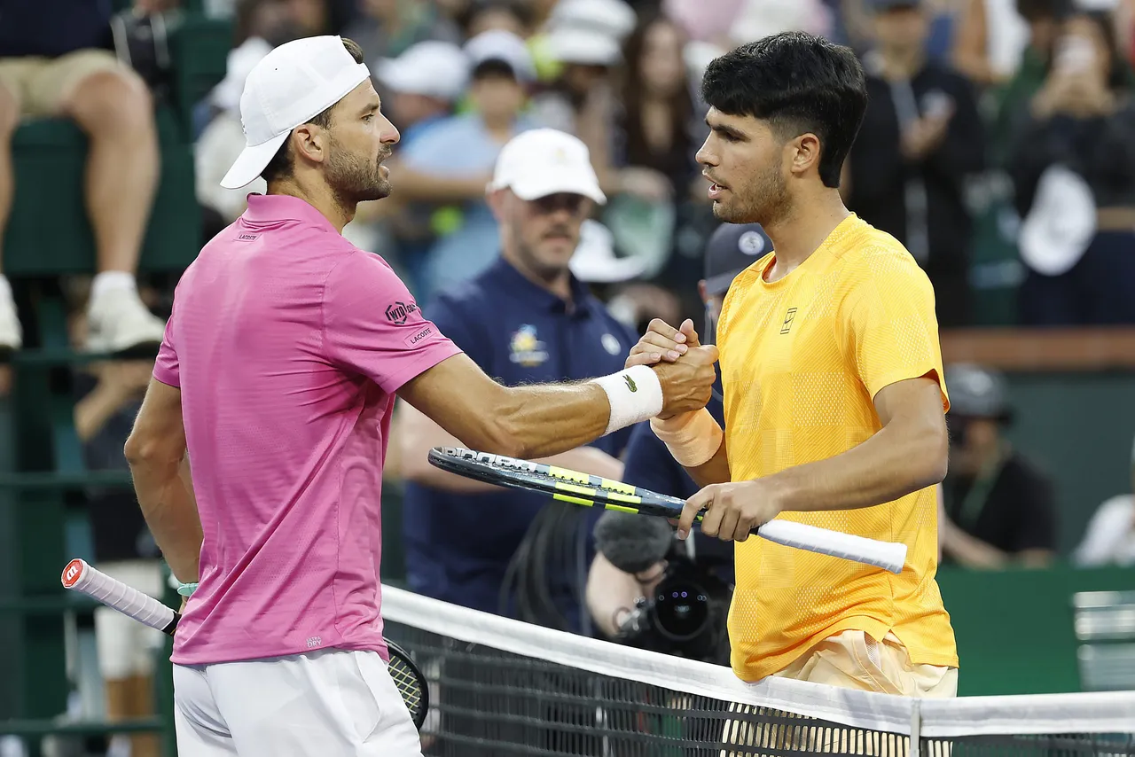 Carlos Alcaraz of Spain (R) greets Grigor Dimitrov of Bulgaria (L) at the net after Alcaraz