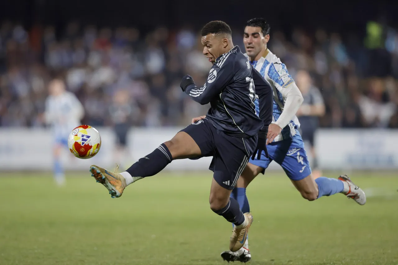 El delantero francés del Real Madrid, Kylian Mbappé, golpea el balón ante el jugador del Talavera, Álvaro López