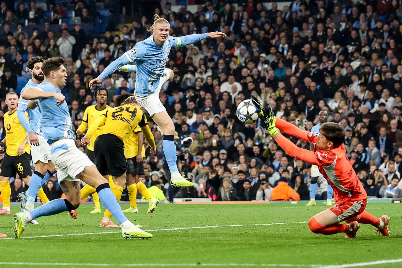 Erling Haaland of Manchester City (C) and goalkeeper Gregor Kobel of Borussia