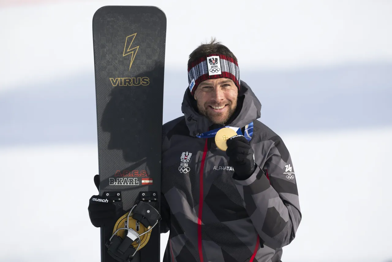 Gold medal winner Benjamin Karl of Austria poses with the medal after the snowboard parallel