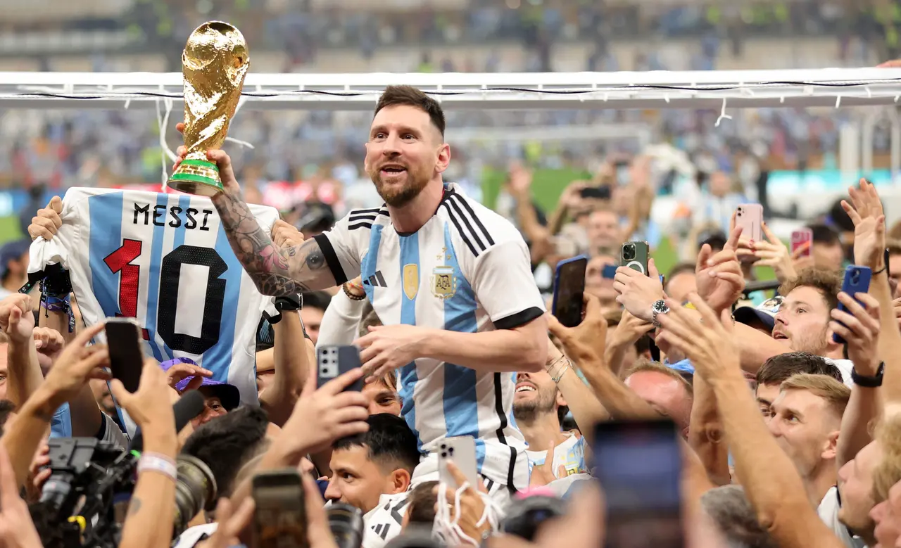 Lionel Messi (C) of Argentina lifts the World Cup trophy after winning the FIFA World Cup 2022 Final between Argentina and France at Lusail stadium