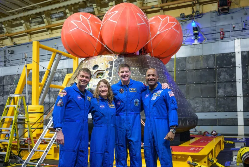 Los astronautas de Artemis II posan para una foto grupal después de observar su nave espacial Orion —que ellos nombraron Integrity— en la cubierta inferior del USS John P. Murtha tras su amerizaje.