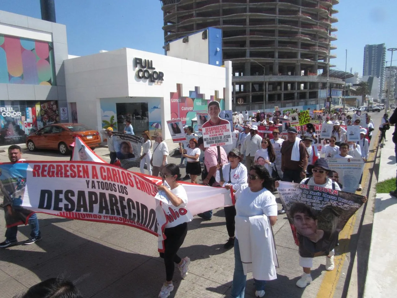 “Madres y colectivos marchan por el Malecón de Mazatlán con pancartas y fotografías para exigir justicia por jóvenes desaparecidos.”