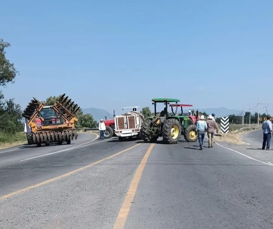 Productores de maíz retirando tractores de bloqueos carreteros en Michoacán.