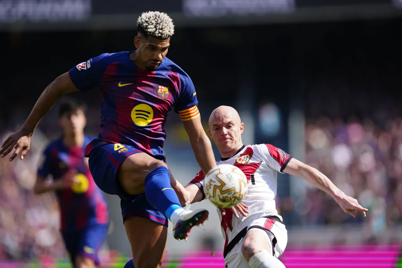 El jugador del FC Barcelona Ronald Araujo (i) lucha por el balón con Isi (d), del Rayo Vallecano