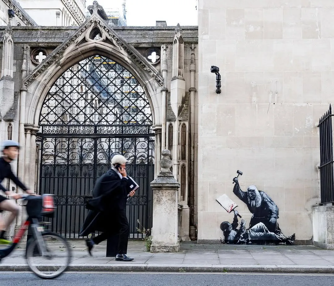 Obra de Banksy en Londres representando a un juez golpeando a un manifestante.