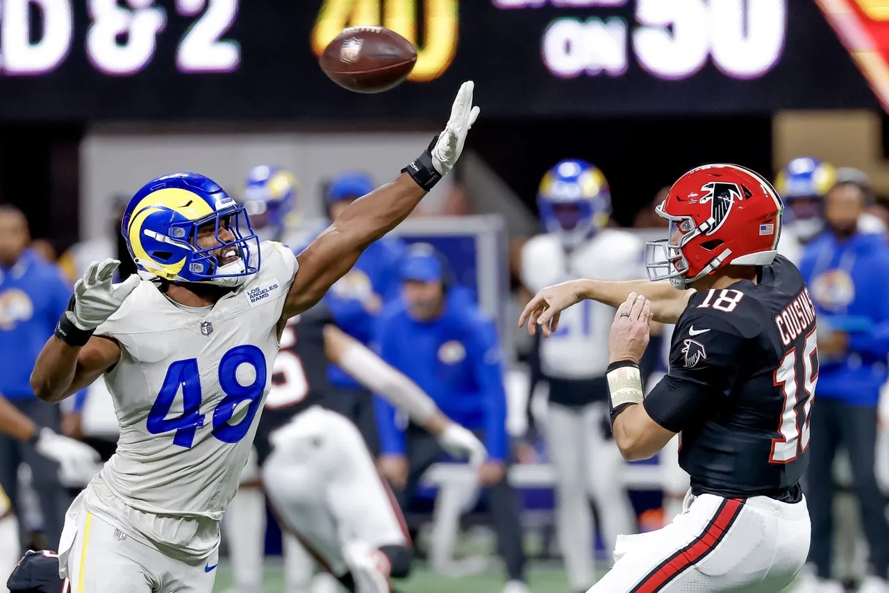 tlanta Falcons quarterback Kirk Cousins (R) passes under pressure from Los Angeles Rams