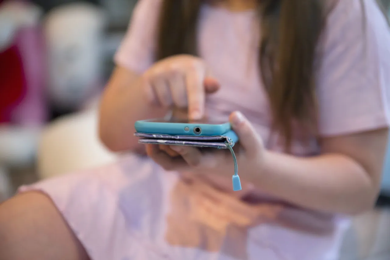 crop-girl-browsing-smartphone
