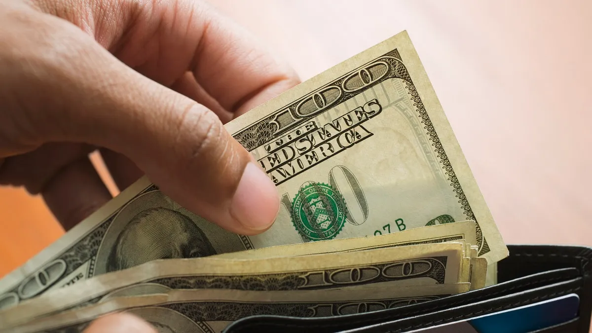 Mixed Race man taking money out of wallet