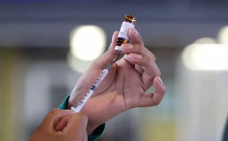 Personal médico aplicando vacunas para cortar la transmisión del sarampión entre menores y adultos