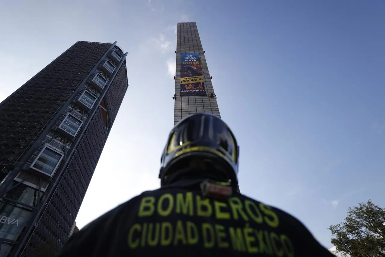 Activistas de Greenpeace escalando la Estela de Luz en CDMX