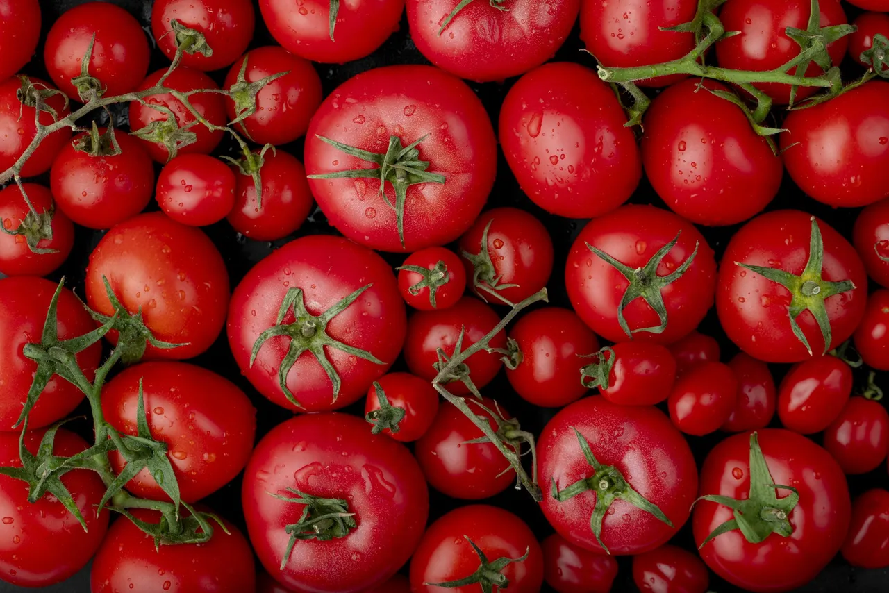 top view of ripe fresh tomatoes with water drops on black background